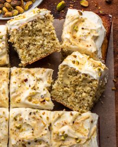 sliced carrot cake with cream cheese frosting and pistachios on the side