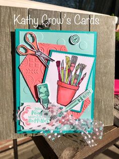 a close up of a card on a wooden bench with scissors and other crafting supplies