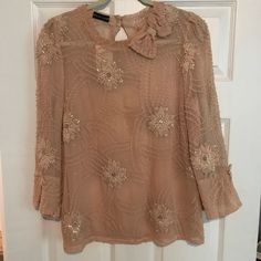 Nwt. Sheer Silk Blouse By Spanish Designer, Pilar Ruiz. Fits Sizes Small To Medium. Flowy Fit With Bow Details And Intricate Flower Appliqus. Split Sleeve At Bottom With Keyhole Back. Color Is A Light Peach/Salmon Hue. Beautiful Top And Have Never Seen Anything Like It Before. Purchased At United Apparel Liquidators, Which Is Known For High-End Unique Pieces. Light Peach, Silk Blouse, Unique Pieces, Top Blouse, Womens Tops, Silk, Color