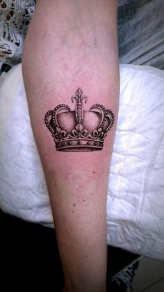 a black and white crown tattoo on the leg