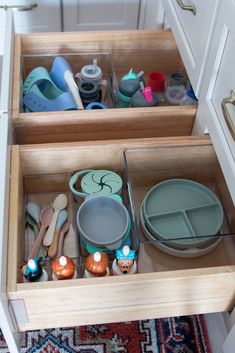 an open drawer with dishes and utensils in it