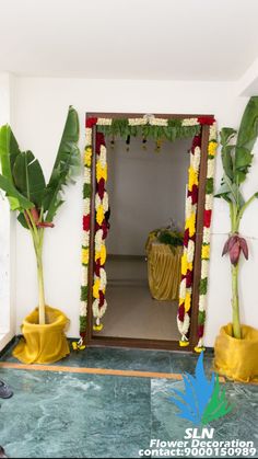 an entrance to a room decorated with flowers and plants on the floor, in front of a mirror