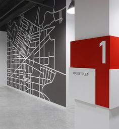 an empty room with white walls and red painted letters on the wall, along with a large city map