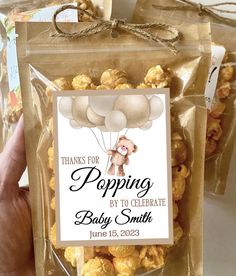 a person holding up a bag of popcorn with the label for popping by to celebrate baby smith on it