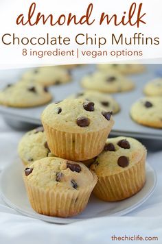 several chocolate chip muffins on a plate next to a tray of muffins