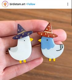 two small birds wearing hats on their fingers