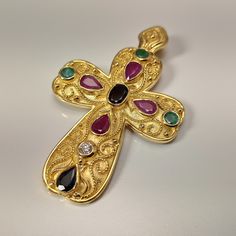 Byzantine style Greek Cross made of 18 carat solid yellow gold with genuine precious gemstones The Cross is decorated with different shapes Rubys,Sapphires,Emeralds and a Diamond 0.10 ct. Total weight of te colored stones is 3.20 ct. The specific Croos has been manufactured in one of the oldest jewelry workshops in Athens which is famous for production of byzantine jewelry It is a handmade Cross with spirals and grains Made in Greece inspaired by Byzantine art jewelry A beautiful piece of jewelr Byzantine Style Yellow Gold Cross Jewelry, Gold Byzantine Cross Jewelry, Byzantine Cross Jewelry Gift, Gold-plated Byzantine Jewelry, Byzantine Hallmarked Cross Jewelry, Byzantine Fashion, Byzantine Jewelry, Ancient Greek Coin, Greek Coins