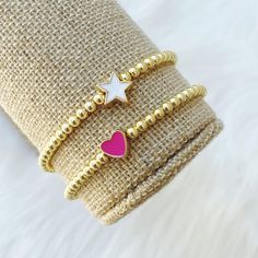 A cool, lightweight stretch bracelet. Uniquely crafted with 3mm gold plated hematite beads and accented with a white star or pink heart bead. This listing is for ONE bracelet! This bracelet stretches to fit small to medium sized wrists (approximately 7 inches long). Size customization available free of charge - leave your desired dimensions in the comment section with your order. Please email me with any questions: sarahndipityjewelry [!at] gmail.com. Pink Heart Bracelet With Round Beads In Dainty Style, Pink Dainty Heart Bracelet With Round Beads, Dainty Pink Heart Bracelet With Round Beads, Trendy Gold Stretch Bracelet With Heart Beads, Trendy Gold Beaded Heart Bracelet, Trendy Gold Bracelets With Heart Beads, Trendy White Heart Charm Bracelet, Gold Heart Stretch Bracelet For Friendship, Trendy Gold Stretch Bracelet For Valentine's Day