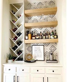 a kitchen with white cabinets and shelves filled with bottles