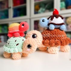 three crocheted stuffed animals sitting next to each other on top of a table