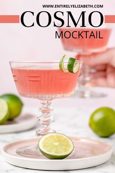 a close up of a drink in a glass on a plate with limes around it