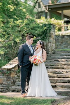 a bride and groom standing in front of some steps