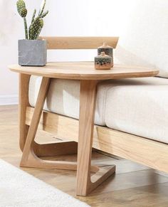 a wooden table sitting on top of a white couch next to a potted plant