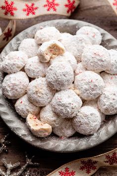 a plate full of snowball cookies on top of a table