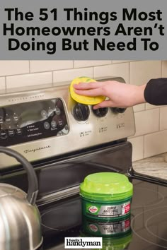 someone is cleaning the stove with a sponge