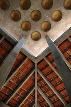 the inside of a building with wooden roofing and ceiling lights hanging from it's rafters