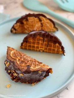 three waffles on a plate with chocolate frosting