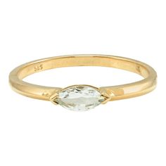 a yellow gold ring with an oval cut white topazte in the center, set on