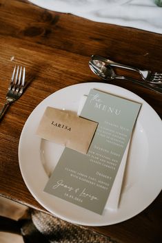 a table setting with place cards and silverware on it, along with napkins