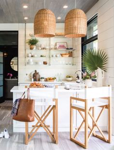 two wooden stools sitting in front of a kitchen island with white counter tops and open shelves