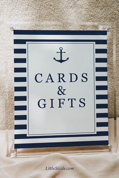 a sign that says cards and gifts with an anchor on the front in black and white stripes