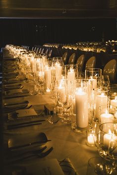 a long table is set with candles and place settings for dinner guests to sit at