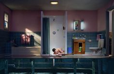 a man laying on top of a bath tub next to a toilet in a bathroom