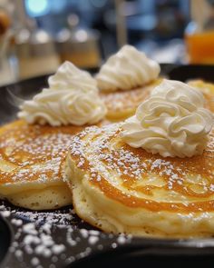 three pancakes with whipped cream on top