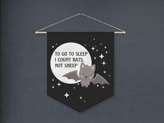 a banner hanging on the wall that says to go to sleep i count bats, not sheep