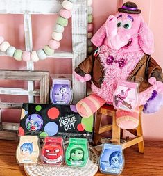 a pink stuffed animal sitting on top of a wooden chair next to other toy items