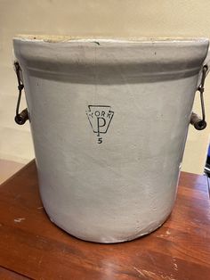 a white bucket sitting on top of a wooden table