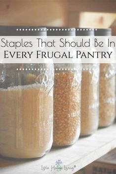 five jars filled with food sitting on top of a wooden shelf next to each other