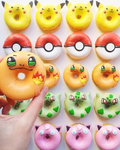 a person holding a doughnut in front of pokemon donuts