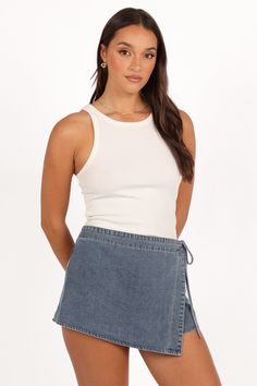 DETAILS   The Ashton Denim Skort in Medium Wash is a versatile addition to any wardrobe, combining the classic look of denim with the playful vibe of a skirt. Its mini length and high-waisted style make it a flattering choice for various body types, while the front faux wrap skirt overlay adds a unique twist to the traditional skort design.   mini length  high waisted style  front faux wrap skirt overlay  side tie detail   front zip closure  back functional pocket  unlined   material - 100% cott Wedding Swimwear, Faux Wrap Skirt, Denim Skort, Black Tie Wedding Guests, White Dress Shoes, Bachelorette Party Outfit, Crop Top Sweatshirt, Crop Top Tees, High Waist Fashion