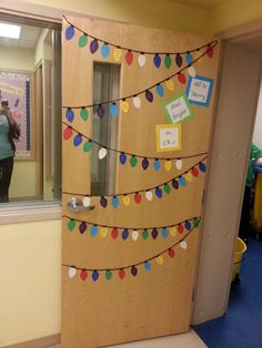 the door to an office decorated with paper garlands and magnets is shown in front of a mirror