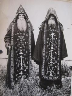 two men with long beards standing next to each other