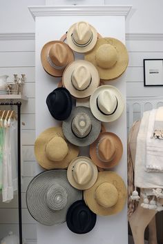 several hats are arranged on a wall in a room with white walls and flooring