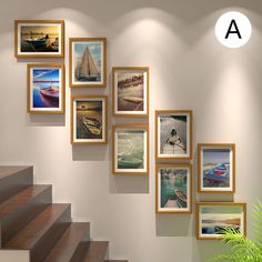 there are many pictures hanging on the wall next to the stair case and potted plant