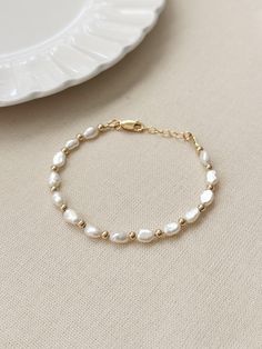 Please review the bracelet sizing guide below for the perfect fit! * 14K Gold Filled or 925 Sterling Silver accents * Choose your length - each bracelet comes with a .75 inch extender chain for adjustable sizing * 7mm genuine irregular Pearls * Made with all hypoallergenic materials 🤍 Bracelet Sizing Guide: 5-6.5 inches = xtra small 6.5-7 inches = small 7-8 inches = medium 8 inches+ = large Each Bracelet is measured held taught from tip to end. Unsure what size to choose? The best way to find the right size is to take a string (even floss) and measure your wrist, then add 1/2 to a full inch depending on the fit you would like. When in doubt, size up! Matching Necklace: https://etsy.me/3LE5ZsL ✨ See more Pearl Jewelry here!: https://etsy.me/3zMbXyh GET TO KNOW MAGBEE JEWELRY! ✨  🤍 All Mag 14k Gold Filled Round Bead Bracelets For Wedding, Wedding Beaded Bracelets 14k Gold Filled With Round Beads, 14k Gold Filled Beaded Bracelets For Wedding, 14k Gold Filled Round Beads Bracelet For Wedding, 14k Gold Filled Round Bead Wedding Bracelets, 14k Gold Filled Beaded Wedding Bracelets, Classic Polished Pearl Bracelet As A Gift, Classic Polished Pearl Bracelet As Gift, Classic Polished Pearl Bracelet Gift