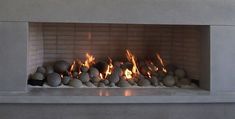 a fire place with rocks in it and flames coming out from the top one side