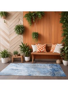 a wooden bench sitting next to some potted plants on top of a blue rug