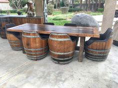 a wooden table sitting next to three wine barrels