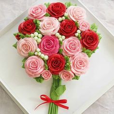 a bouquet of pink and red roses on a white plate