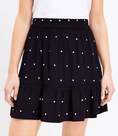 a woman is wearing a black and white polka dot skirt with ruffle hems