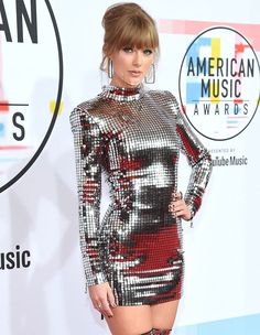 taylor swift at the american music awards wearing a silver and red dress with high slits