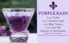 a purple drink in a glass sitting on top of a table