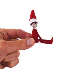 a hand holding a small toy elf sitting on top of it