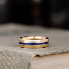 a close up of a wedding ring on top of a book with a cloth in the background