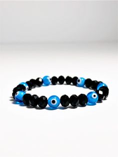 Evil eye bracelet made with black crystals and light blue evil eye beads, all strung together in high quality elastic. Super easy to put on and stack with other bracelets. The light blue evil eye is for general protection from spiritual harm. This eye also helps to bring peace and helps the wearer appreciate the alone time. Evil Eye: 8 mm Product made in USA Receive FREE SHIPPING with your order of $35 or more Light Blue Evil Eye, Jewelry Evil Eye, Kabbalah Bracelet, Bracelet Evil Eye, Evil Eye Beads, Turkish Eye, Alone Time, Red Bracelets, Jewelry Beaded