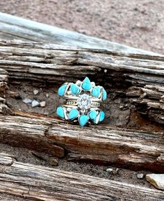 a turquoise ring sitting on top of a piece of wood